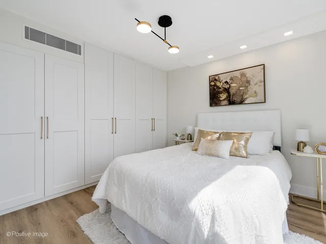 a bedroom with a bed and a painting on the wall