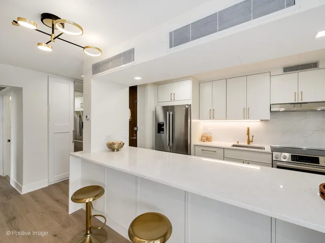 a kitchen with stainless steel appliances granite countertop a sink a stove a refrigerator and cabinets