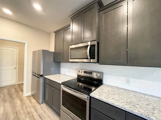 a kitchen with granite countertop stainless steel appliances and wooden cabinets