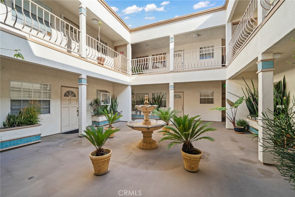 1145 Roswell Avenue, Unit 204 Long Beach, CA 90804 - Photo 3 of 14 a view of a building with potted plants and a chair