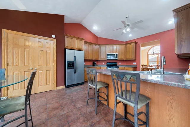 a kitchen with stainless steel appliances granite countertop a refrigerator a sink a stove and cabinets