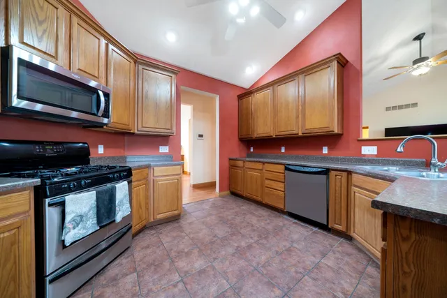 a kitchen with stainless steel appliances granite countertop a stove a sink and a microwave