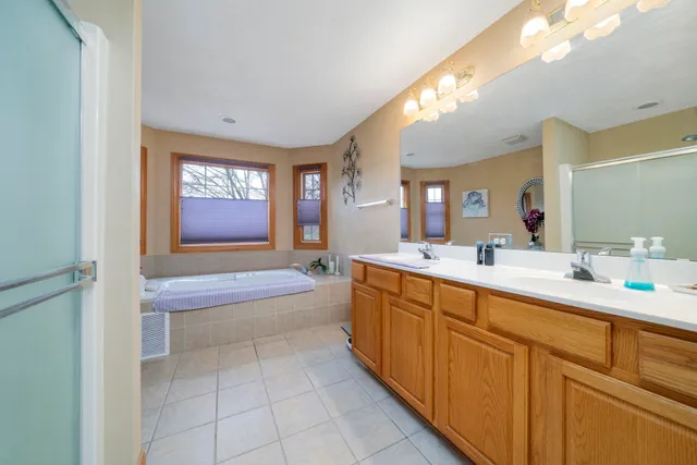 a spacious bathroom with a tub sink and mirror