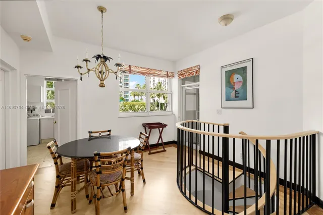 a view of a dining room with furniture a chandelier and wooden floor