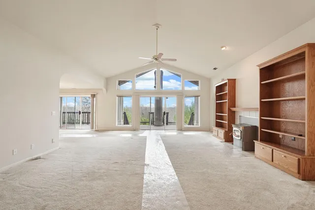 an empty room with chandelier fan