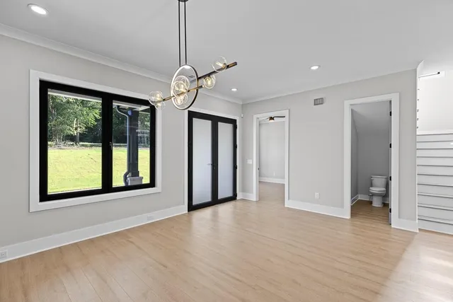a view of an empty room with a window and wooden floor