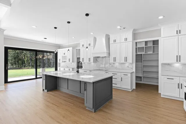 a kitchen with a refrigerator a sink dishwasher and a stove with wooden floor