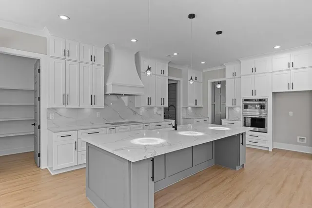 a large kitchen with stainless steel appliances a large counter top a sink a stove and a refrigerator