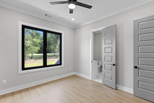 an empty room with closet and a ceiling fan