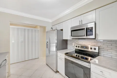a large kitchen with kitchen island a sink stainless steel appliances and cabinets