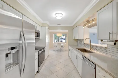 a kitchen with white cabinets and stainless steel appliances