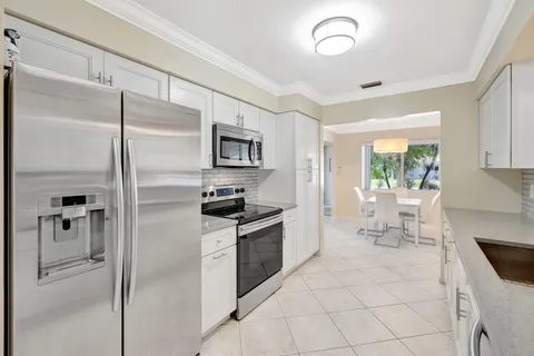 a large white kitchen with a sink and cabinets