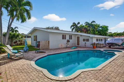 a view of a house with swimming pool and sitting area
