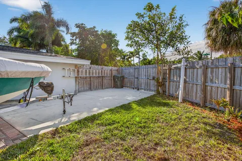 a view of a backyard with a chair and potted plants