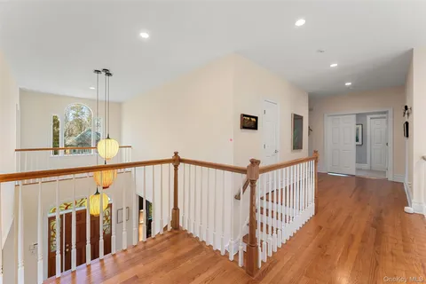 a view of a hallway with wooden floor and stairs
