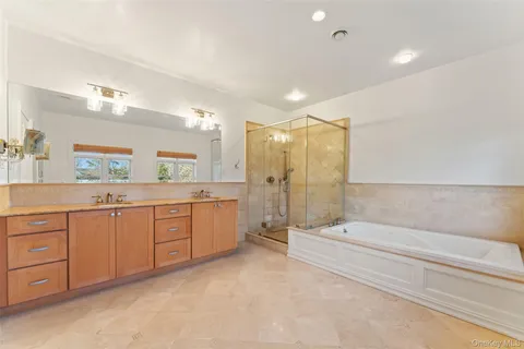 a bathroom with a tub sink shower and mirror