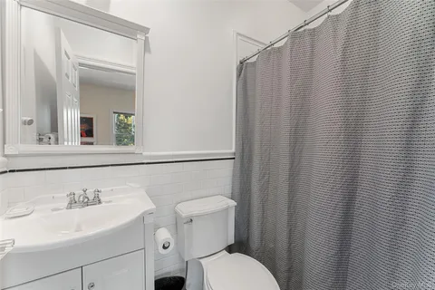 a bathroom with a sink a toilet and shower curtain
