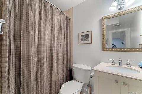 a bathroom with a granite countertop sink toilet and mirror