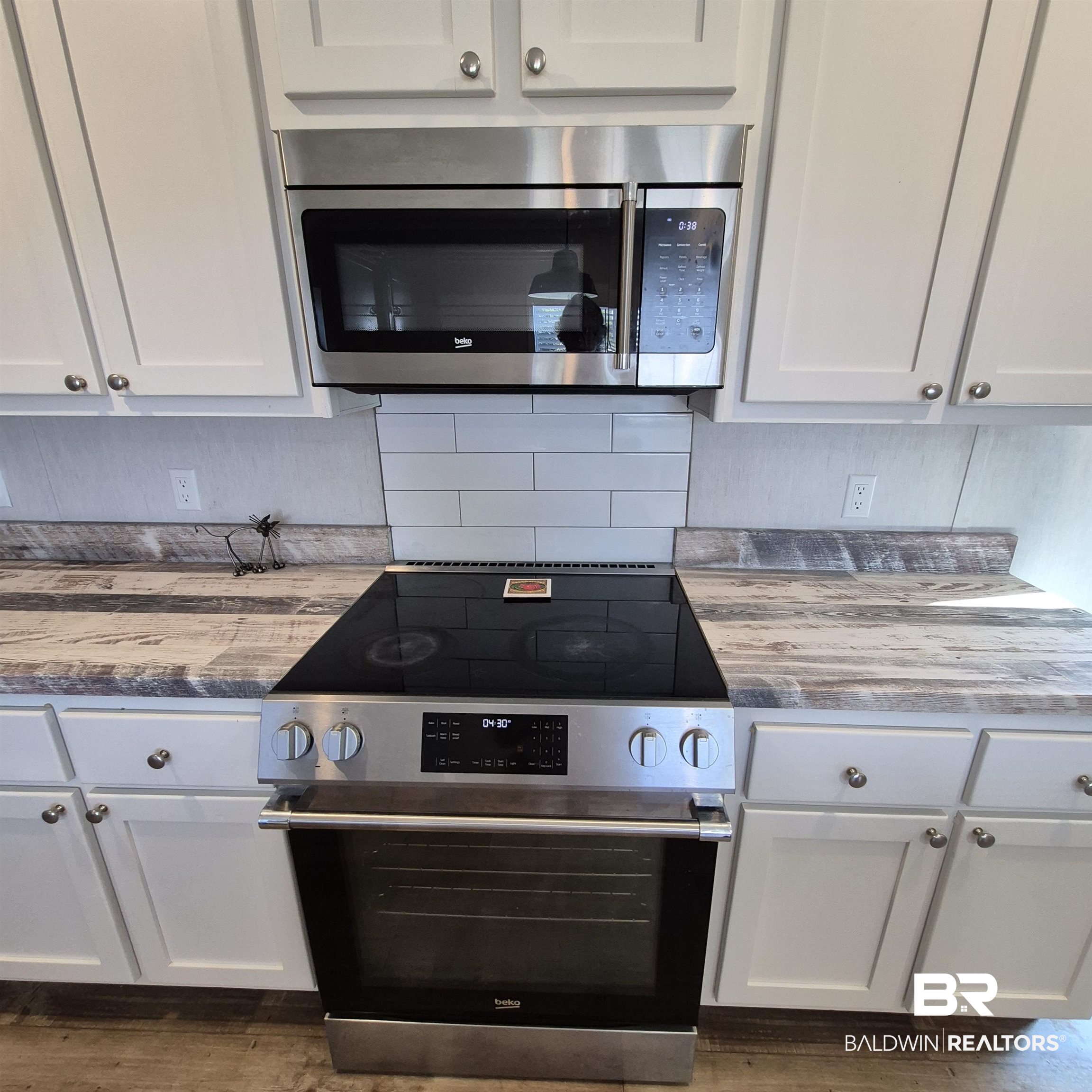 8867 Old Stage Road Repton, AL 36475 - Photo 9 of 37 Kitchen featuring stainless steel appliances, white cabinetry, and dark wood-type flooring