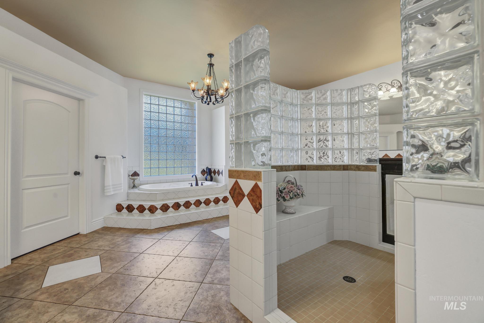 1301 Kanaka Rapids Road Buhl, ID 83316 - Photo 21 of 50 Spacious bathroom featuring a built-in soaking tub with decorative tile surround and a large glass block window