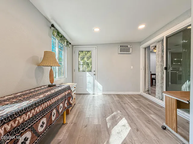 a view of a bedroom with wooden floor and windows