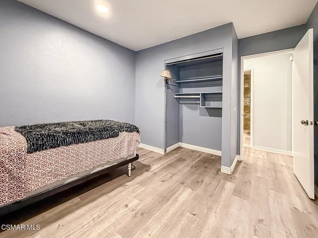 a bedroom with a bed and a refrigerator