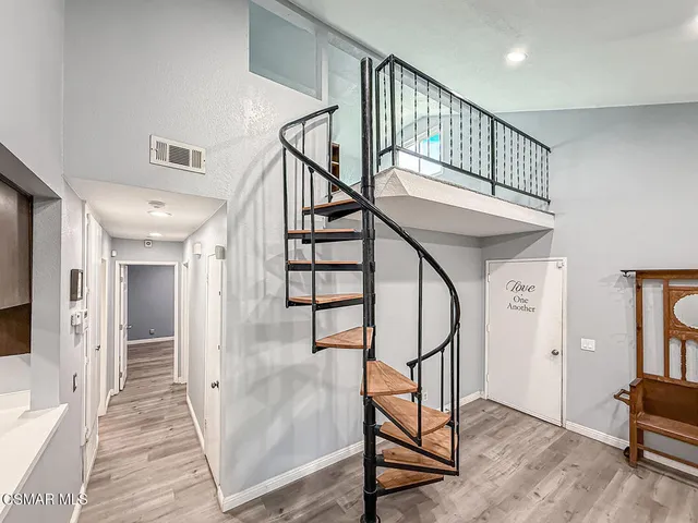 a view of an empty room with stairs and a window