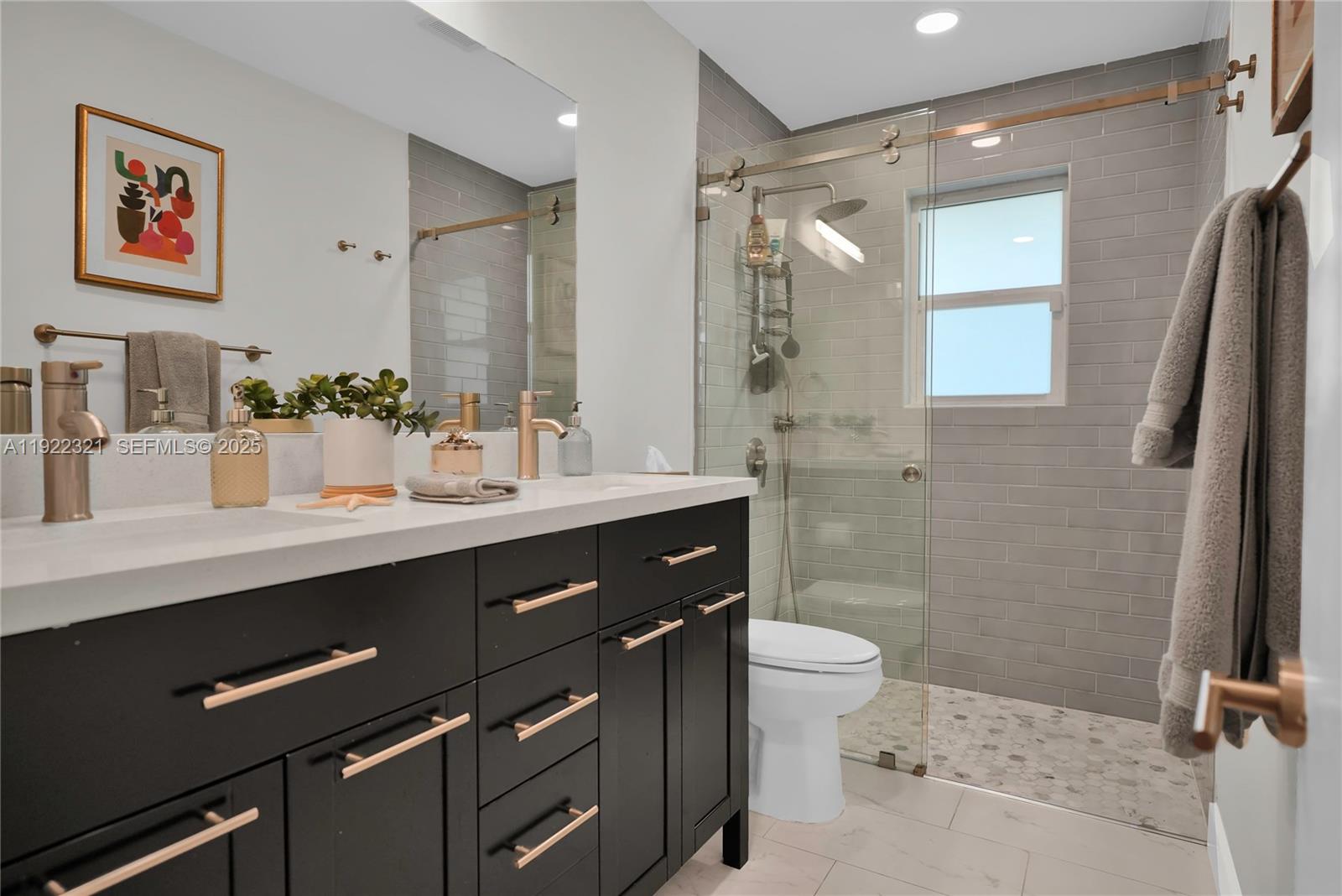 1409 Bird Road Coral Gables, FL 33146 - Photo 16 of 36 a bathroom with a double vanity sink toilet and a mirror