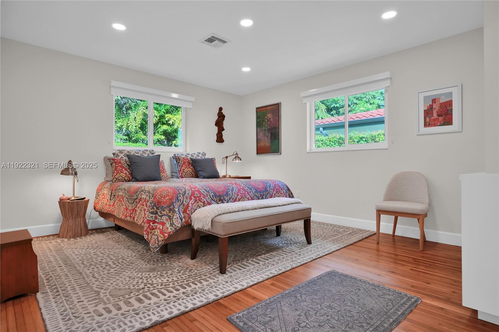 1409 Bird Road Coral Gables, FL 33146 - Photo 10 of 36 a bedroom with a bed wooden floor and a potted plant