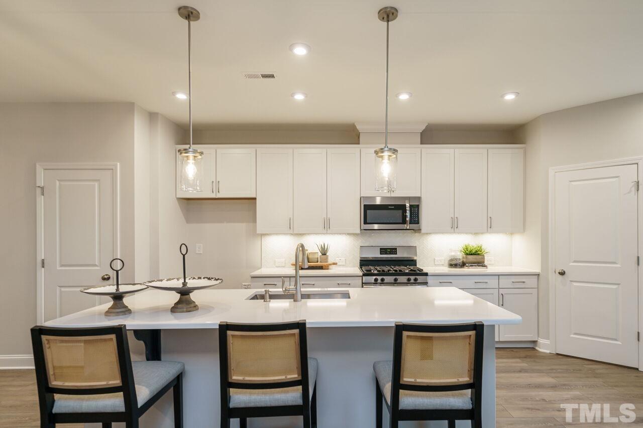 3111 Dunnock Drive, Unit 4 Durham, NC 27713 - Photo 9 of 26 a kitchen with a sink stainless steel appliances and white cabinets