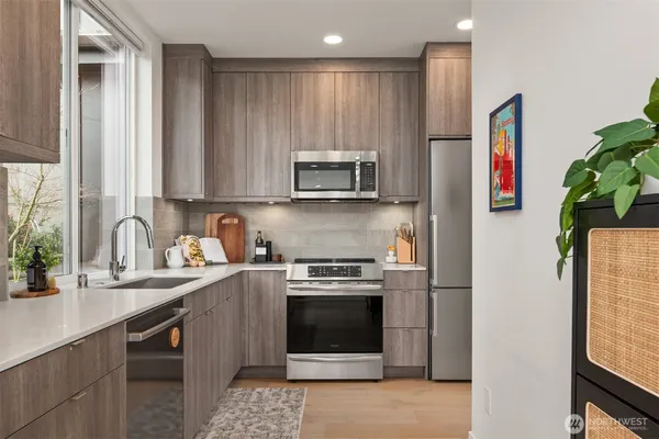 a kitchen with stainless steel appliances granite countertop a stove a sink and a refrigerator