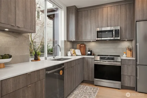 a kitchen with stainless steel appliances granite countertop a sink a stove and a microwave