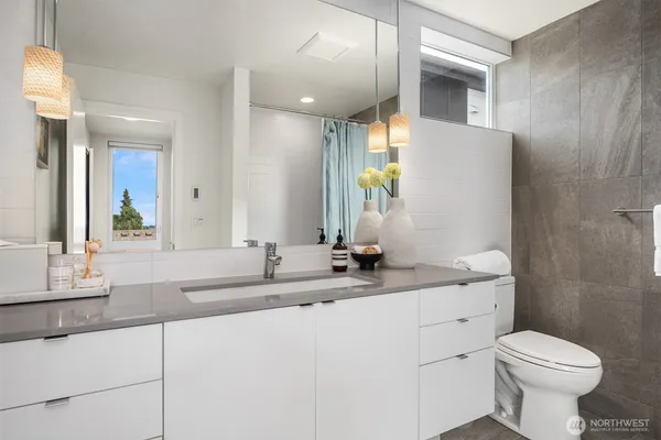 a bathroom with a granite countertop sink mirror and toilet