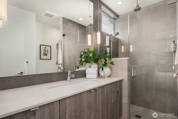 a bathroom with a granite countertop sink a mirror and a shower