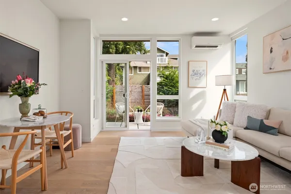 a living room with furniture potted plant and a large window