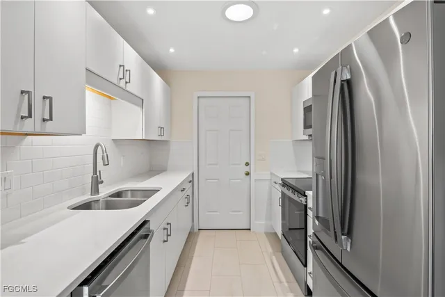 a kitchen with a sink stainless steel appliances and cabinets