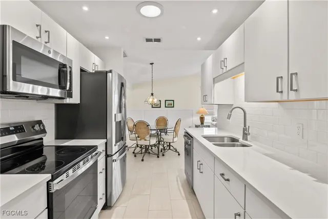 a living room with furniture a chandelier fan and a window