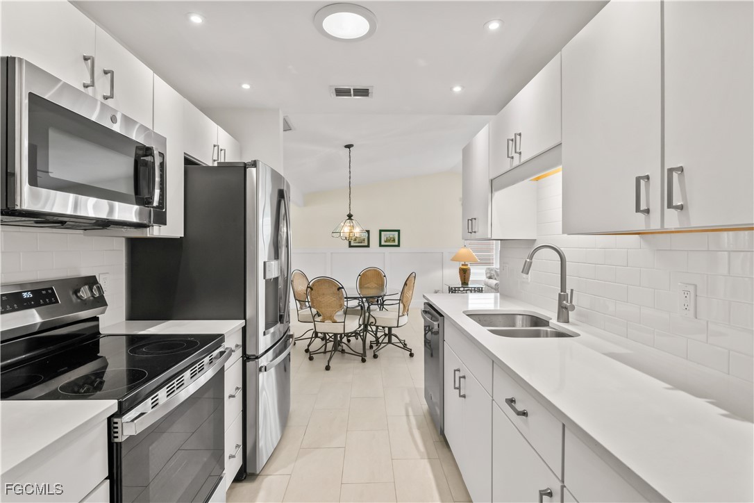 2781 Bruce Street Matlacha, FL 33993 - Photo 14 of 39 a kitchen with a sink stainless steel appliances and cabinets