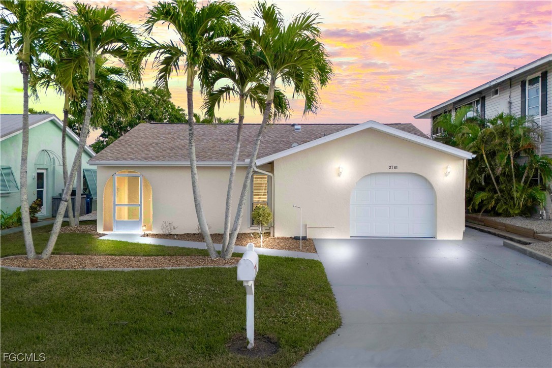 2781 Bruce Street Matlacha, FL 33993 - Photo 4 of 39 a front view of a house with a yard and garage