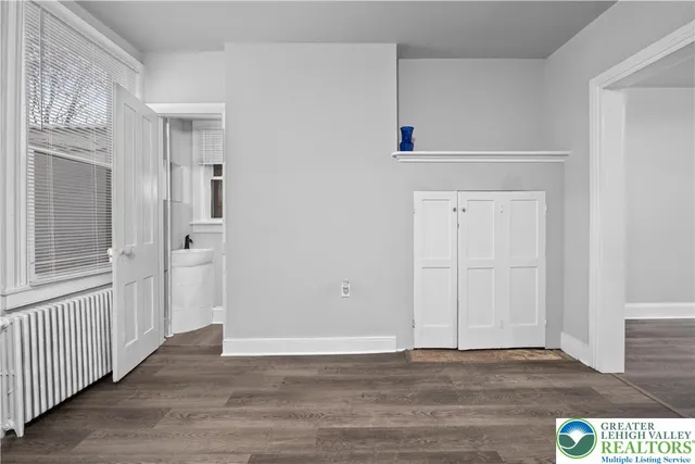 a view of an empty room with wooden floor