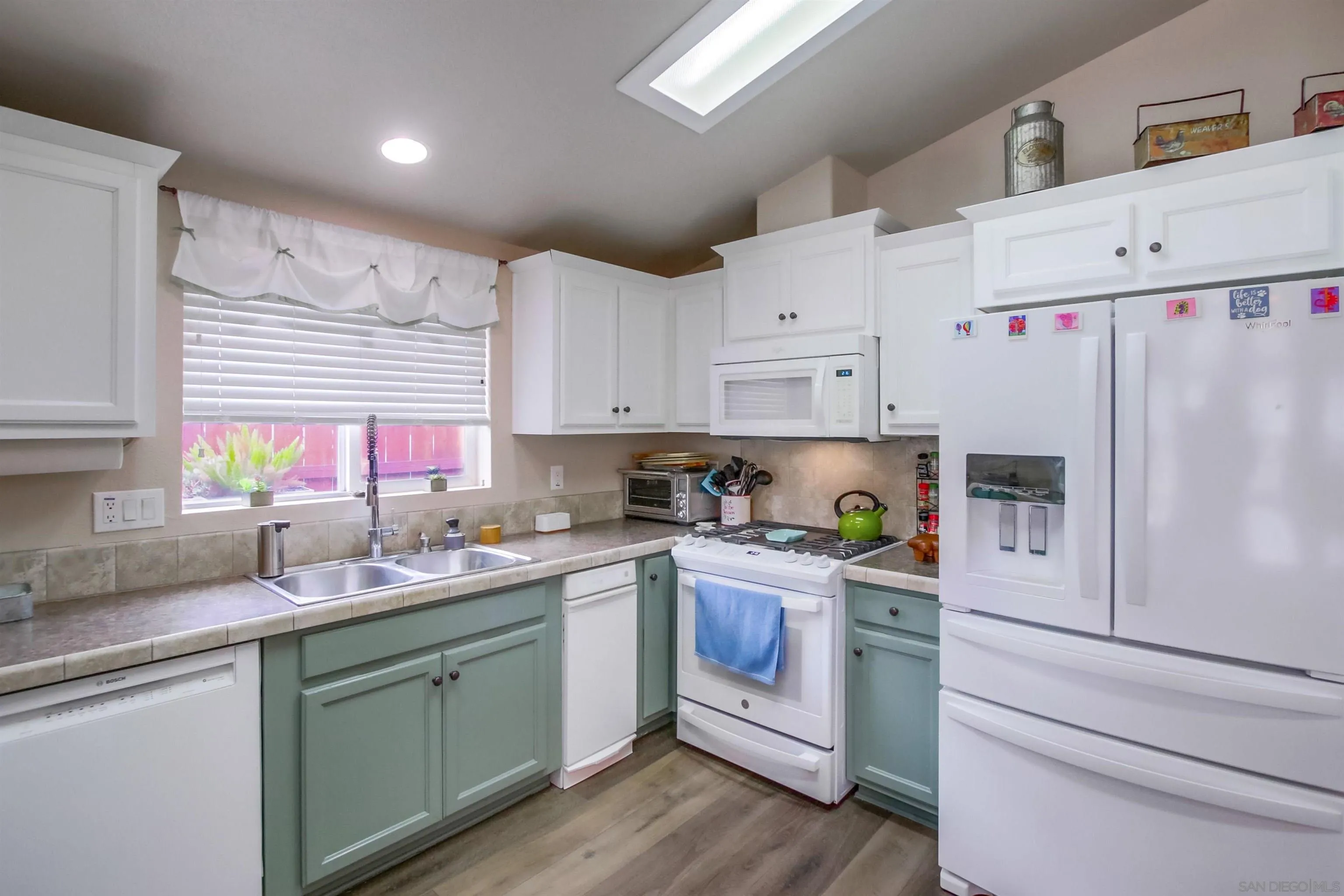 15935 Spring Oaks Road, Unit SPACE 16 El Cajon, CA 92021 - Photo 11 of 45 a kitchen with white cabinets white appliances and sink