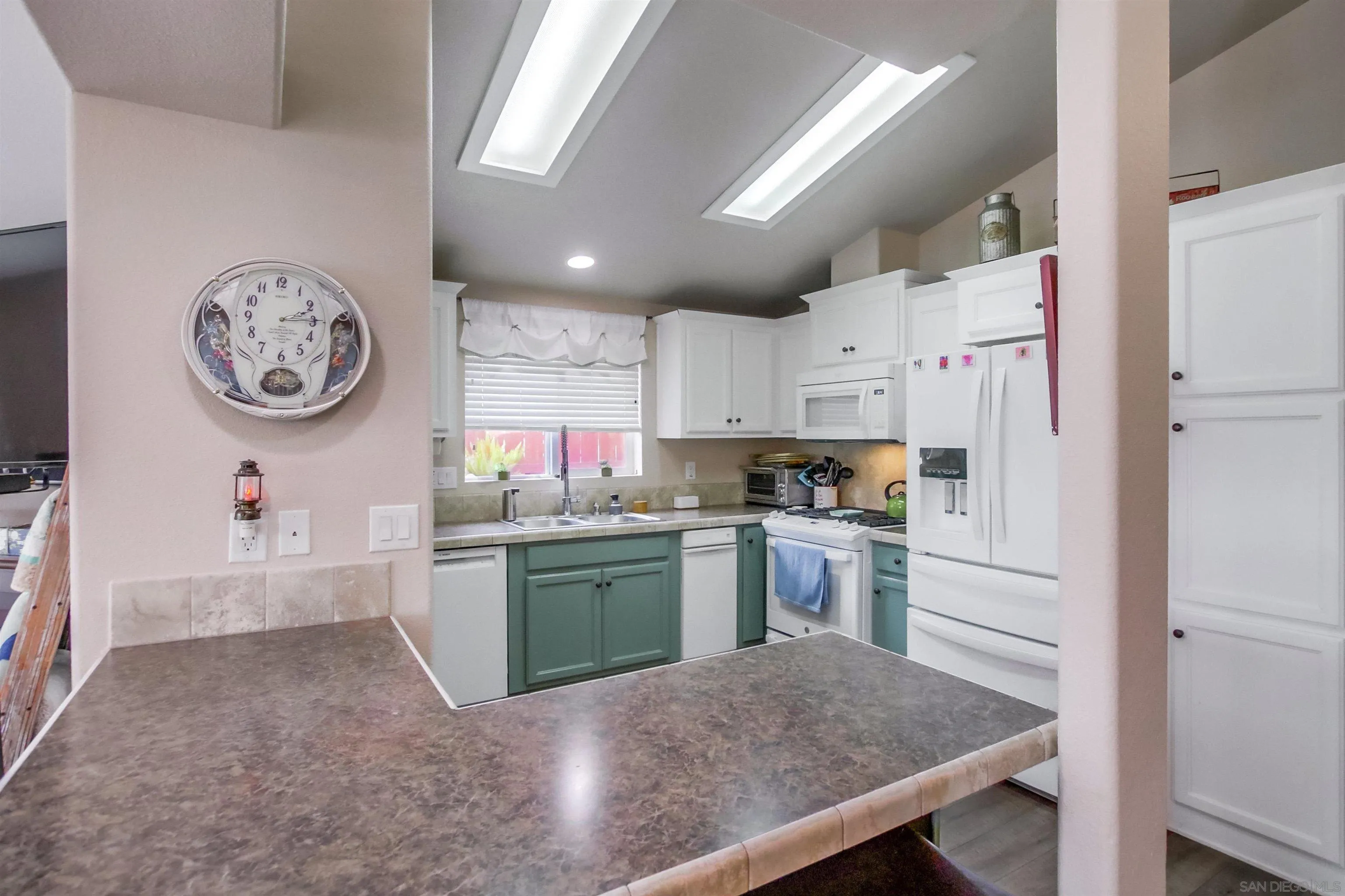 15935 Spring Oaks Road, Unit SPACE 16 El Cajon, CA 92021 - Photo 10 of 45 a kitchen with granite countertop white cabinets and stainless steel appliances