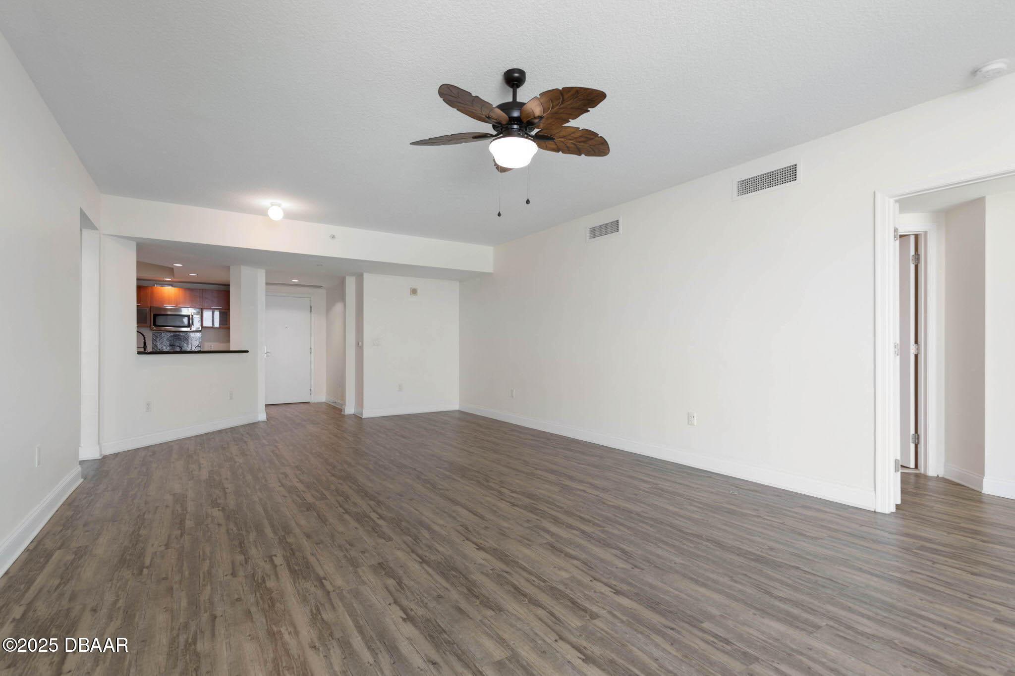 241 Riverside Drive, Unit 708 Holly Hill, FL 32117 - Photo 20 of 80 a view of an empty room with wooden floor and a ceiling fan