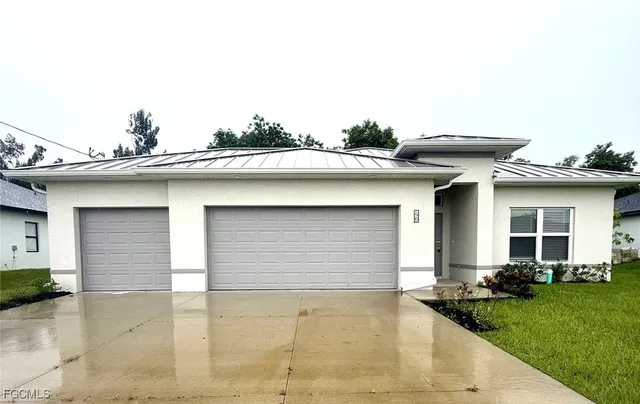 a view of a white house with a large window and yard