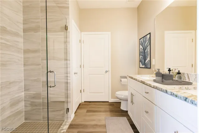 a bathroom with a granite countertop sink a toilet and shower