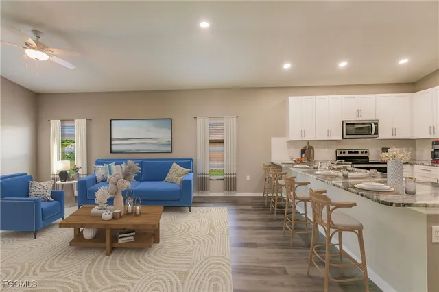 a living room kitchen with furniture and a wooden floor