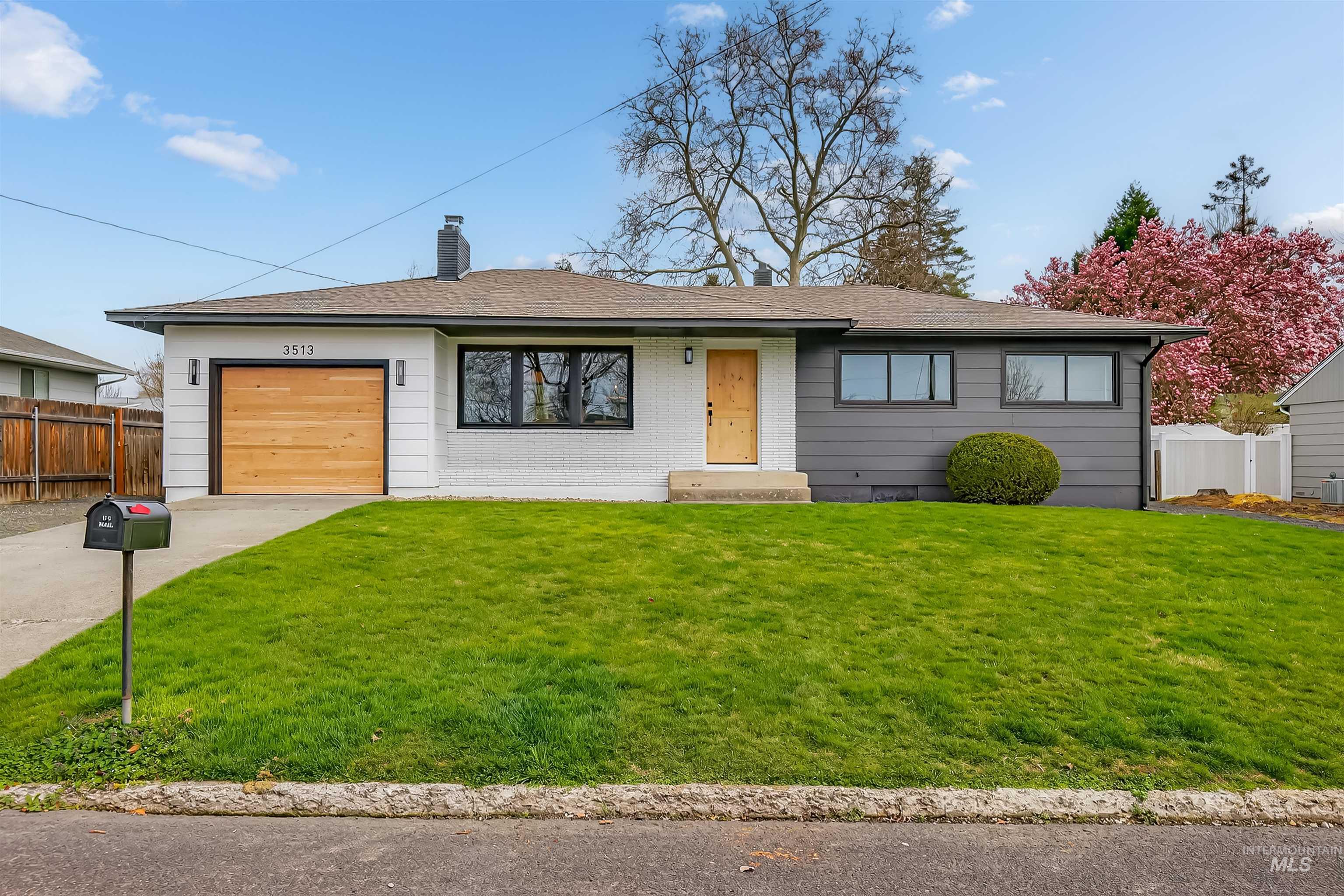 Ranch-style home with a garage, a chimney, concrete driveway, and roof with shingles