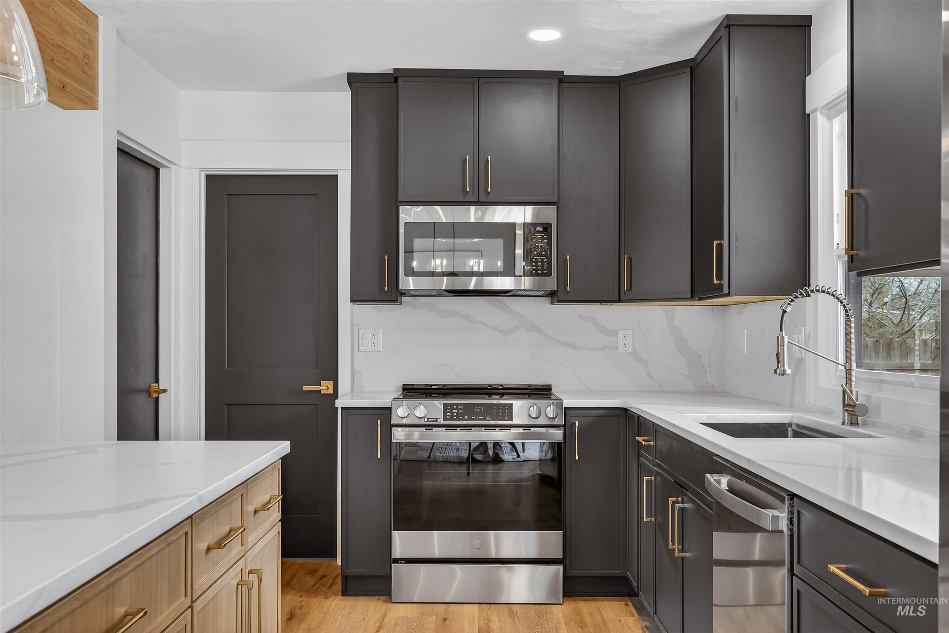 3513 8th Street Lewiston, ID 83501 - Photo 10 of 43 Kitchen with stainless steel appliances, light stone counters, light wood-style floors, backsplash, and recessed lighting