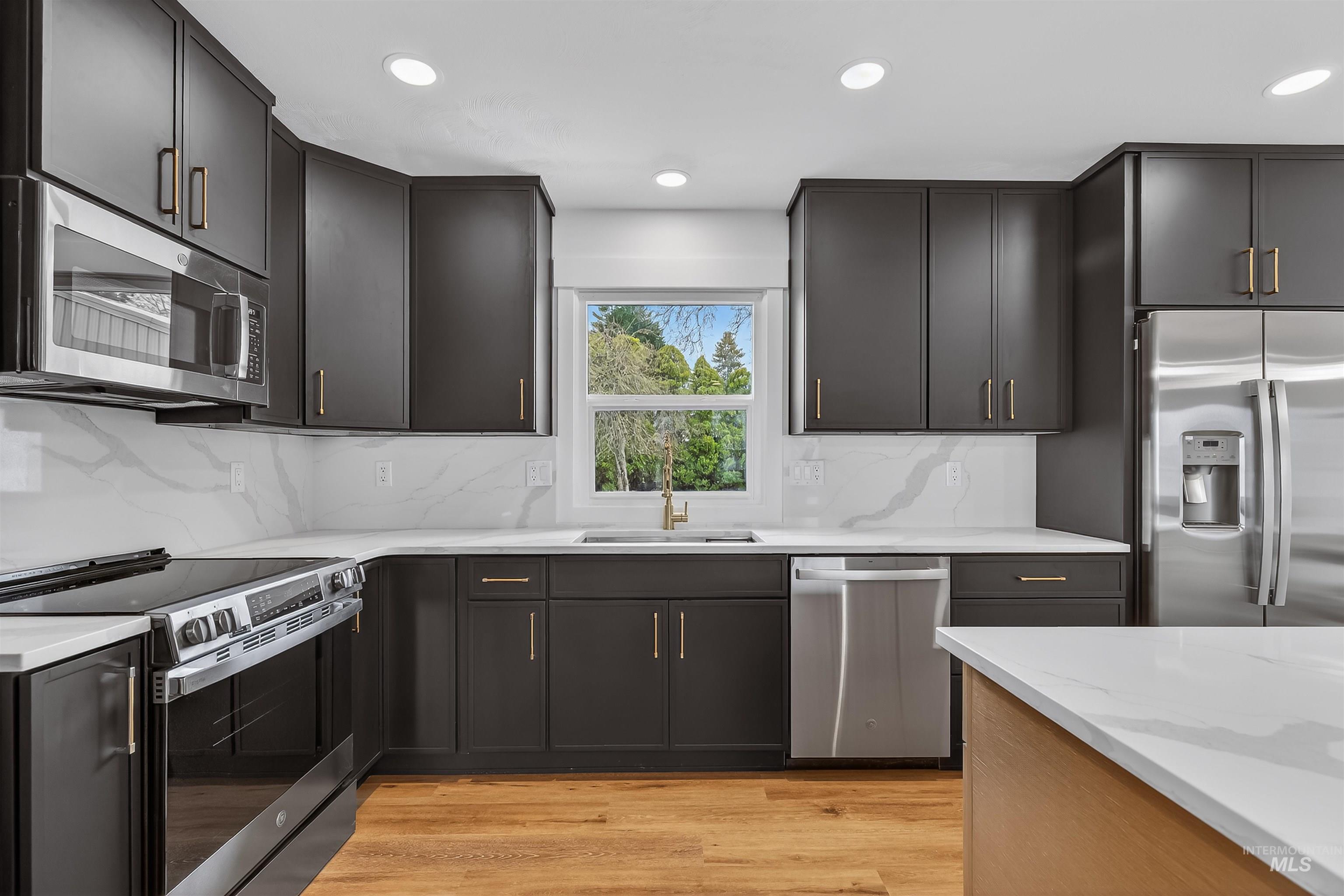 3513 8th Street Lewiston, ID 83501 - Photo 12 of 43 Kitchen with stainless steel appliances, light wood finished floors, light stone countertops, recessed lighting, and backsplash
