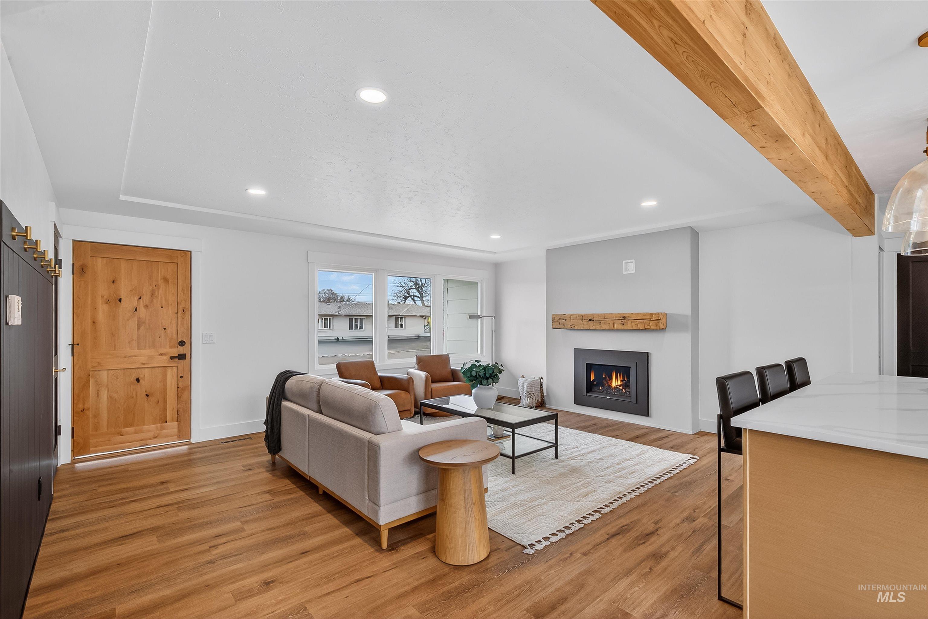 3513 8th Street Lewiston, ID 83501 - Photo 18 of 43 Living area with light wood finished floors, recessed lighting, a lit fireplace, and beamed ceiling